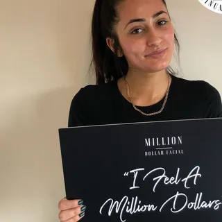 Client with the I Feel A Million Dollars sign after her treatment